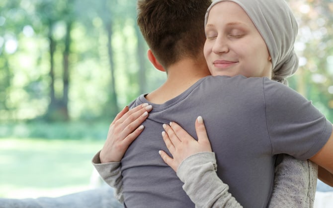 Câlin entre une femme ayant perdu ses cheveux dû au cancer et un ami