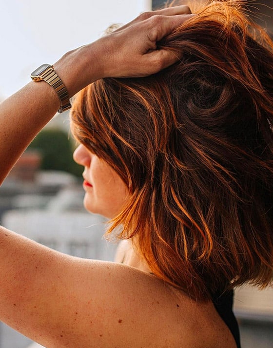 Femme posant la main sur ses cheveux en santé