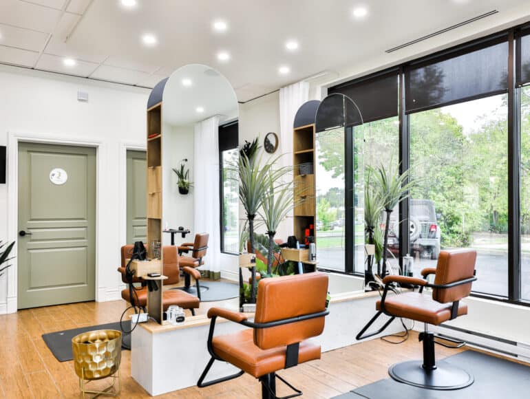 Vue intérieure du salon de coiffure Centre Santé du Cheveu, chaises orangées et miroirs arrondis dans un décor lumineux