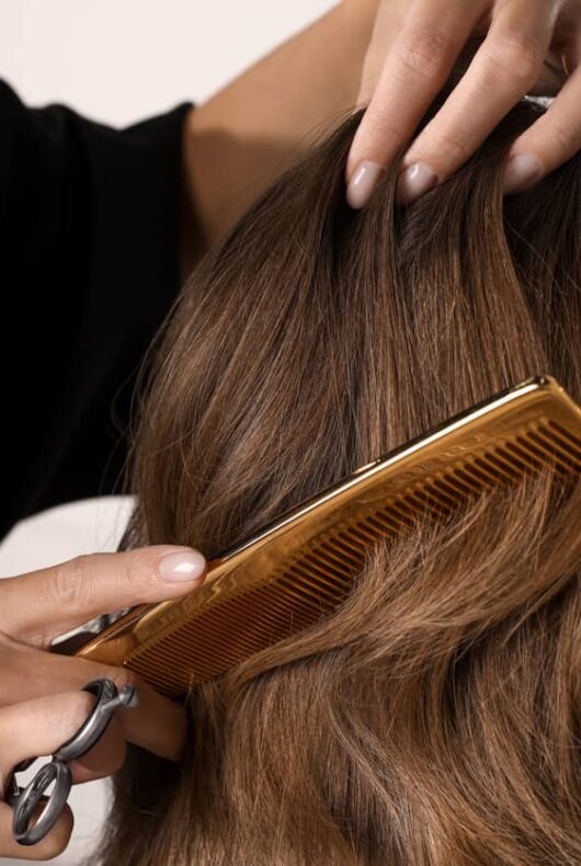 Une styliste prépare une perruque pour femme.