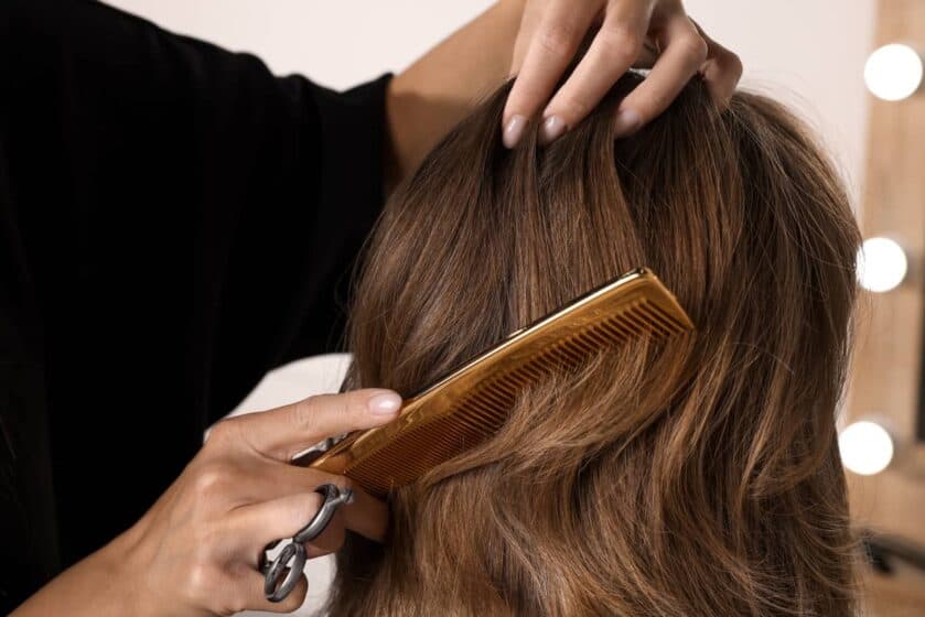 Une styliste prépare une perruque pour femme.
